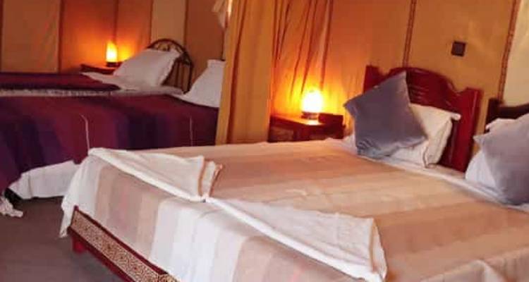 Interior view of a cozy bedroom with two beds and warm lighting.