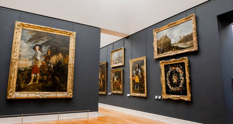 Salle de galerie avec des peintures classiques dans des cadres ornés.