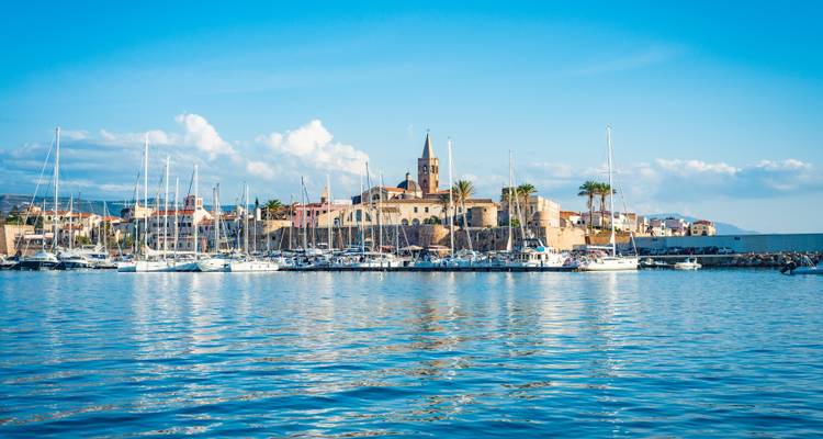 Coastal cityscape with a prominent cathedral tower.