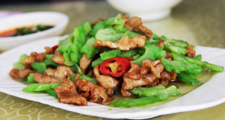Bord met geroerbakte groenten en vlees op een tafel.