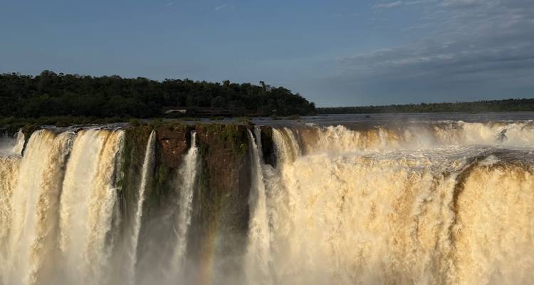 Cascades d'eau dévalant une falaise rocheuse avec des arbres.