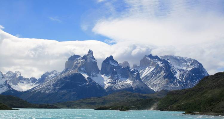 Sneeuw-bedekte bergen onder een gedeeltelijk bewolkte hemel.