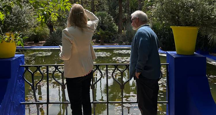 Deux personnes observant un bassin de nénuphars dans un cadre de jardin.