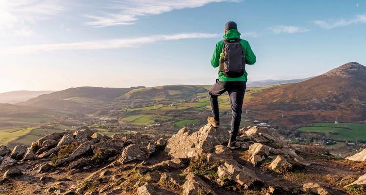 Hiker enjoying a scenic view from a rocky peak.