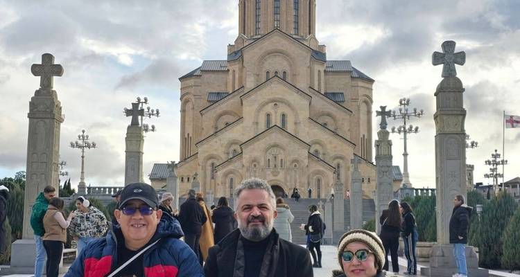 Des personnes se tenant devant la cathédrale de la Sainte-Trinité de Tbilissi.