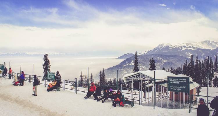 Snow-covered landscape with people enjoying a winter activity.