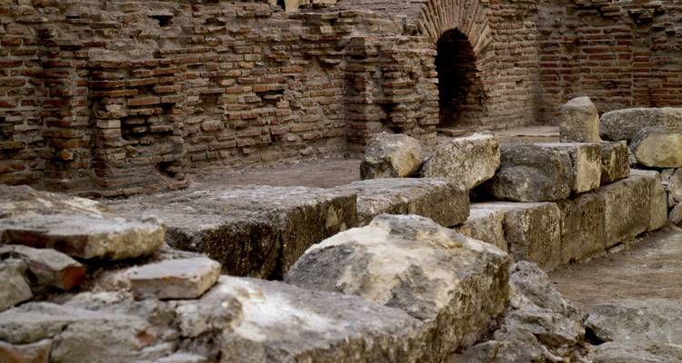 Vestiges d'anciennes ruines avec des blocs de pierre et des arcs.