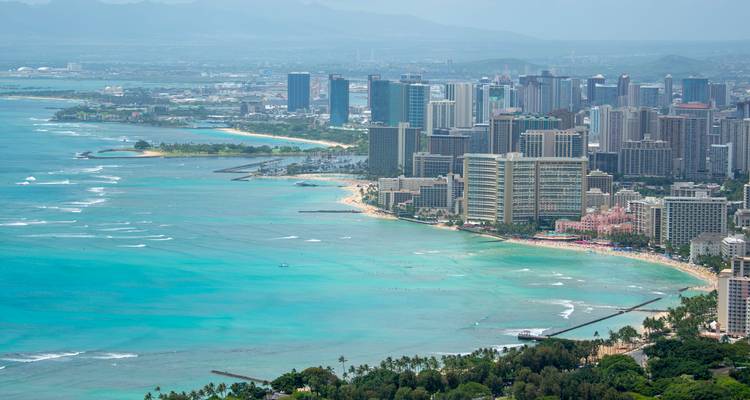 Aerial view of a coastal city with beaches and clear ocean.