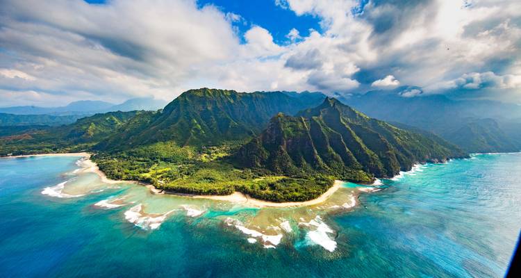 Aerial view of lush mountains meeting the ocean.