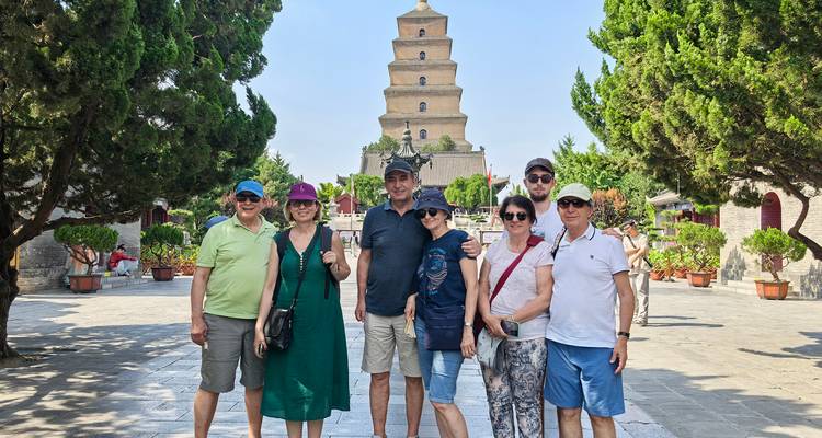 Groep toeristen die voor een historische pagode staan.