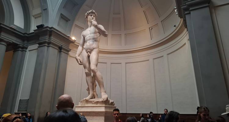 Standbeeld van David omringd door museumbezoekers.