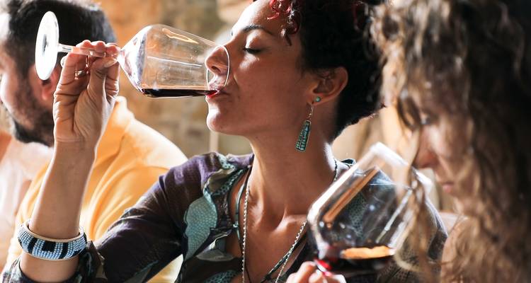 Des gens savourant une dégustation de vin en Toscane.