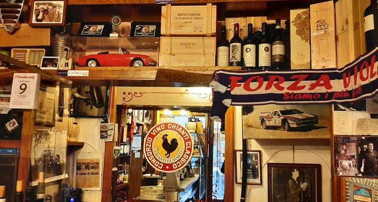 Intérieur d'un restaurant italien rustique avec des bouteilles de vin exposées.