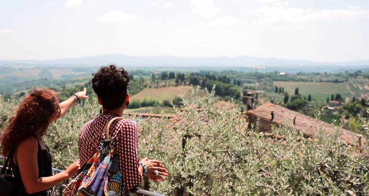 Deux personnes pointant du doigt et regardant une vue panoramique sur la campagne italienne.