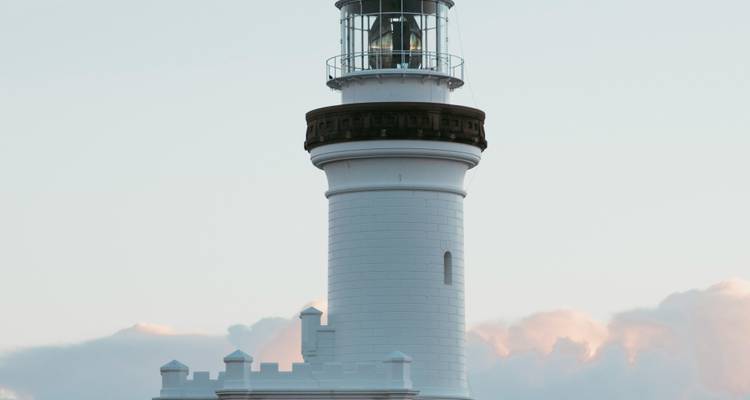 De White Cape Byron Lighthouse steekt hoog uit tegen een bleek avondhemel.