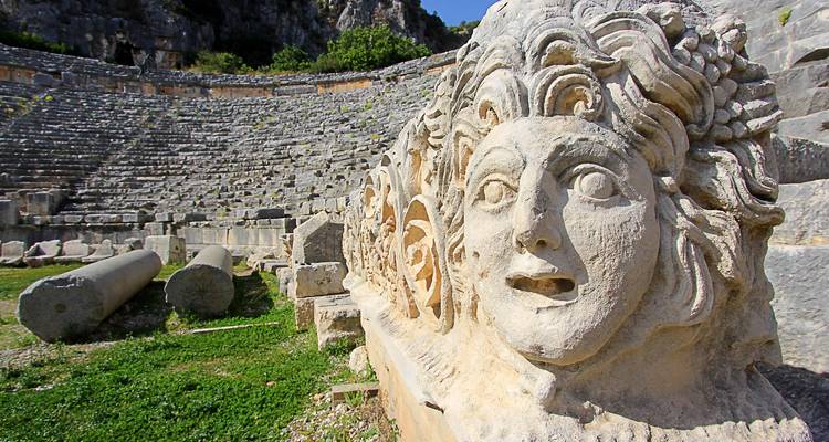 Antiek amfitheater met sculptuurdetails op de voorgrond.