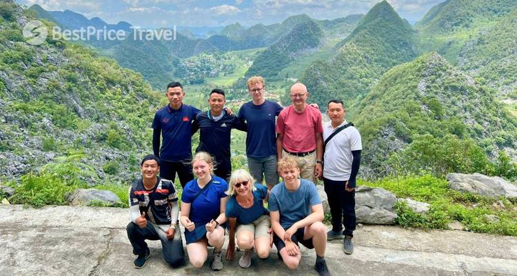 Grupo de personas posando con un fondo montañoso escénico.