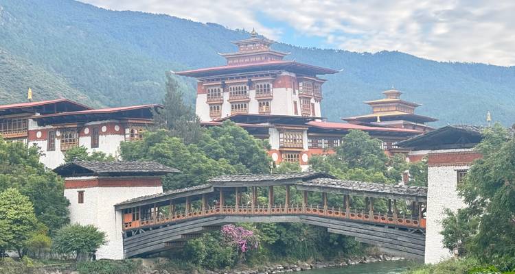 L'élégant Punakha Dzong s'élève au-dessus d'un pont de bois couvert qui enjambe une rivière.