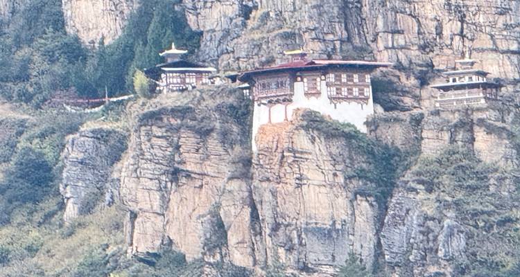 Un ermitage isolé à flanc de falaise s'accroche aux parois rocheuses escarpées, haut au-dessus de la vallée.