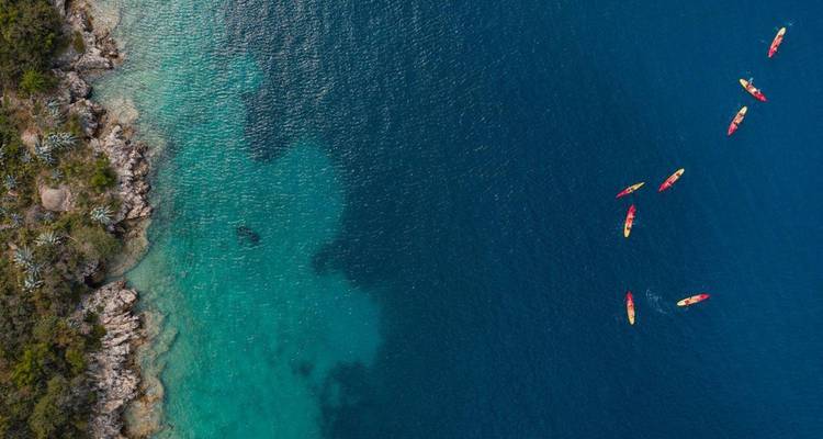 Kayaks colorés flottant près du littoral.