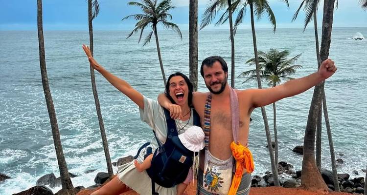 Une famille joyeuse posant dans une zone côtière avec des palmiers.