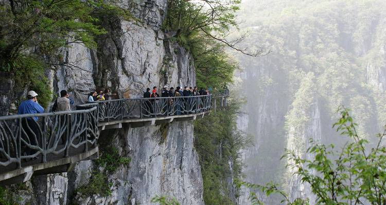 Turistas caminando por un sendero junto al acantilado