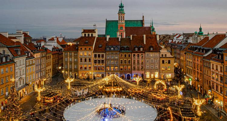 Un mercado navideño festivo con luces centelleantes en la plaza de un pueblo antiguo.