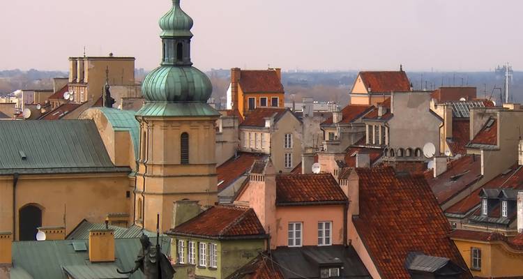 Tejadillos de colores pastel, campanario de iglesia y chimeneas del Casco Antiguo de Varsovia bañados por la suave luz de la tarde.