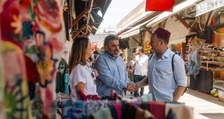 Marktszene mit Menschen, die sich die Hände schütteln.