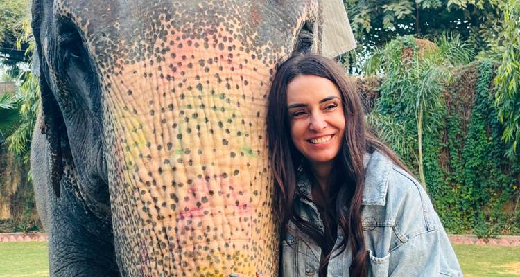 Femme étreignant un éléphant dans un jardin.