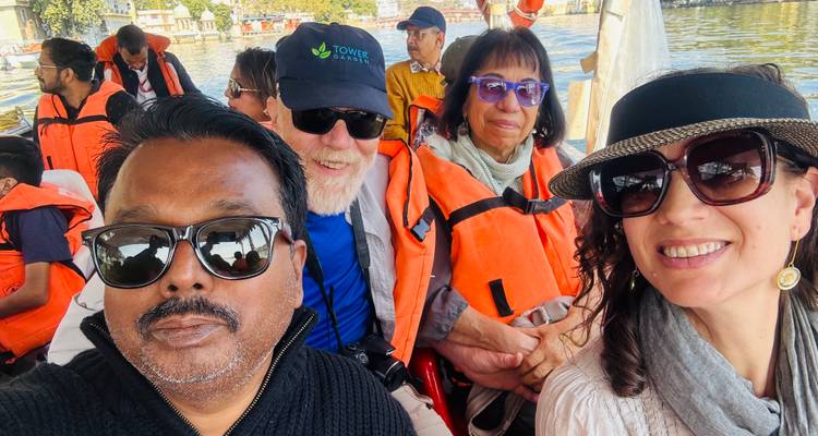 Gruppe von Reisenden in Schwimmwesten, die für ein Selfie lächeln, während sie in einem kleinen Boot sitzen.