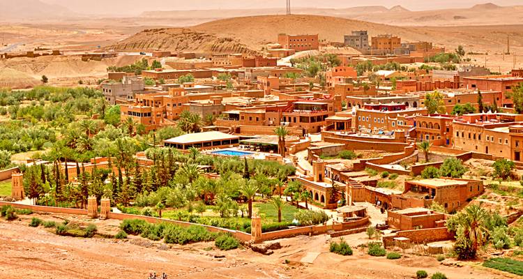 Las casbas de tierra y los jardines verdes de Ouarzazate se extienden por una meseta árida.
