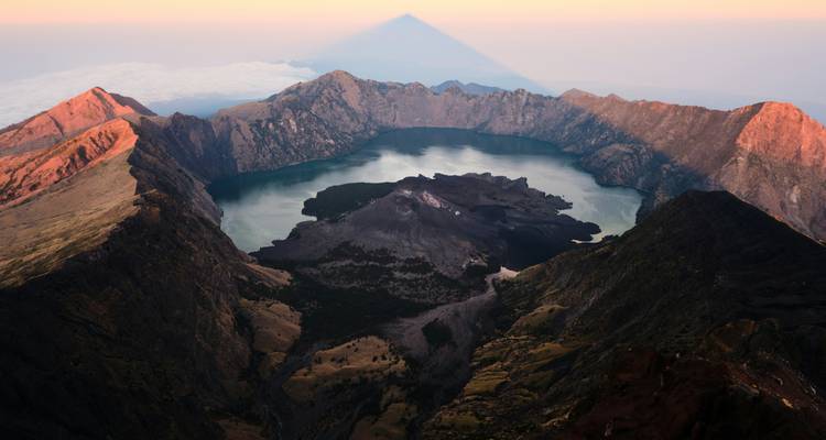 Aerial view of a volcanic crater lake surrounded by mountains.