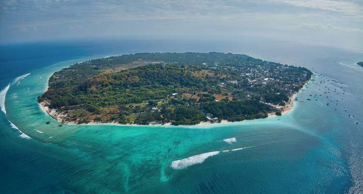Aerial view of a circular island surrounded by turquoise waters.