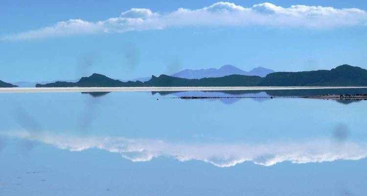 Paysage avec un lac et des montagnes au loin ; semble présenter quelques défauts.