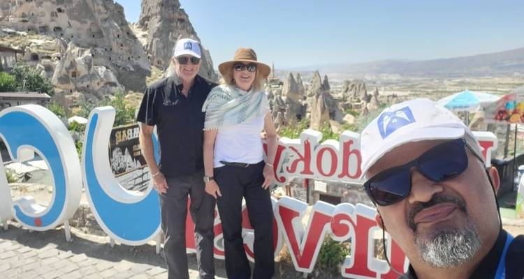 Grupo de tres posando frente a las formaciones rocosas de Capadocia.