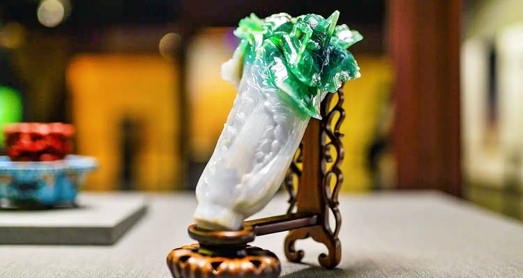 Gros plan de la célèbre sculpture de Chou en jadéite exposée sur un support en bois orné dans un cadre muséal