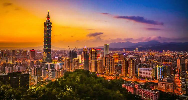 Horizon crépusculaire de Taipei avec la Taipei 101 et les gratte-ciel environnants illuminés sous un ciel orange et violet éclatant