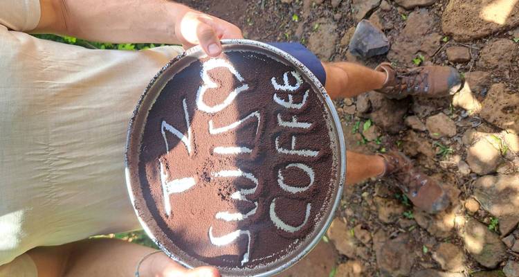 Person, die einen Teller mit gemahlenem Kaffee hält, auf dem der Text 'Tz Switch Coffee' steht.