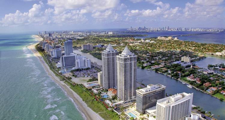 Aerial view of Miami Beach with skyline in the background.