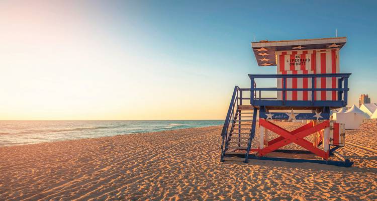 Miami beach with an American-themed lifeguard stand at sunrise.