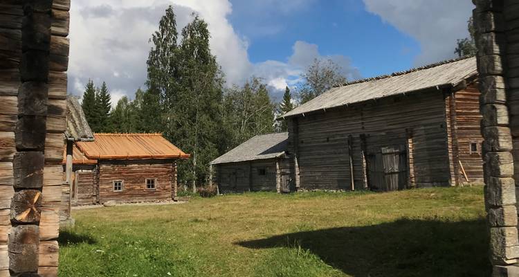Traditionelle Holzgebäude mit Bäumen im Hintergrund.