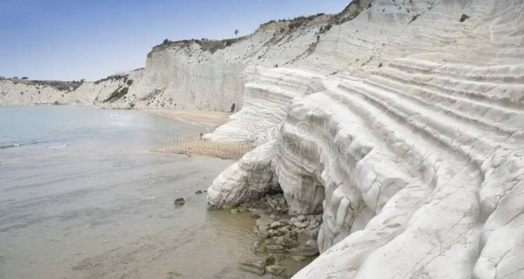 De witte trapvormige rotsen van Scala dei Turchi ontmoeten de turquoise Middellandse Zee.