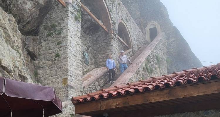 Two people standing on a stone ramp of a foggy historic site.