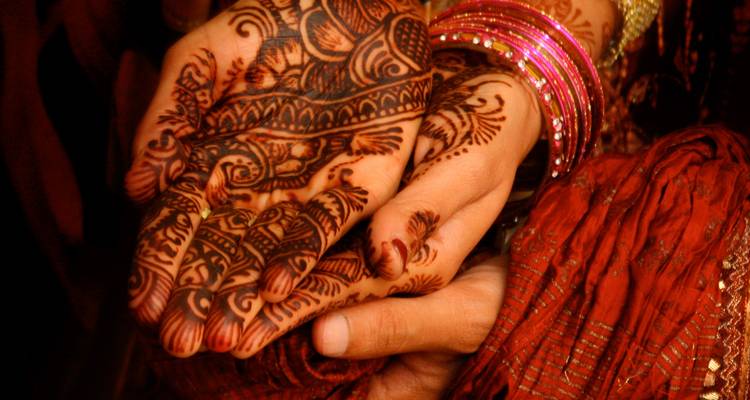 Met henna versierde handen met ingewikkelde mehndi-patronen en kleurrijke bangles