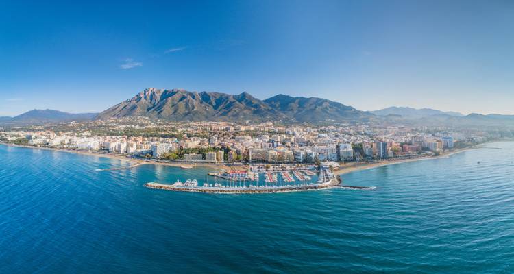 Aerial view of Marbella with mountains and the Mediterranean Sea.