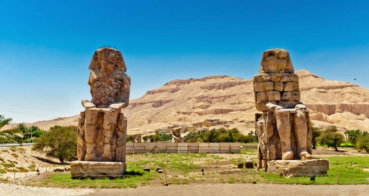 Colossi of Memnon statues with desert backdrop