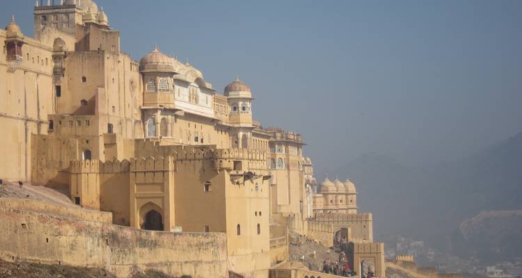 Fort historique d'Amer avec ses murs jaunes et vues sur les montagnes à Jaipur.