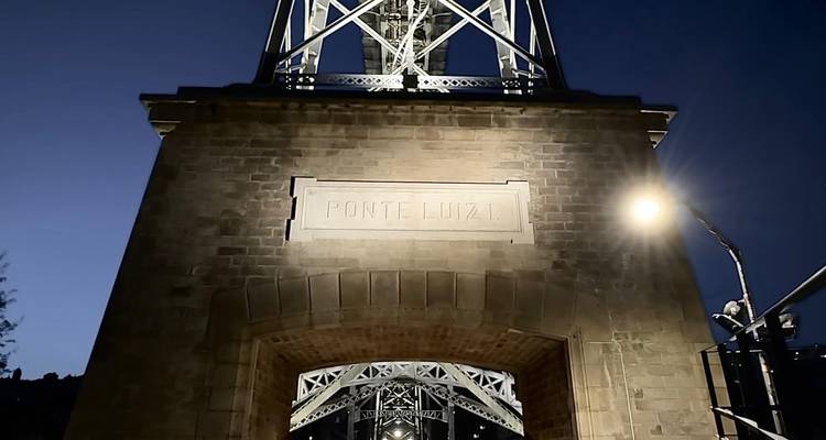 The illuminated Ponte Luiz I arch at night in Porto.