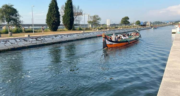 A traditional gondola-like boat on a canal in Aveiro with passengers.